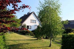 A house with a sloped roof, a visible window, and a well-maintained lawn. - House with lake view (Ratzeburg)