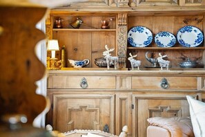 Une commode en bois ornĂ©e dâassiettes dĂ©coratives, une lampe et de petites figurines dâanimaux.