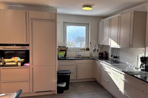 A compact kitchen with a window, a sink, and cabinets. - Holiday apartment WH (Garmisch-Partenkirchen)