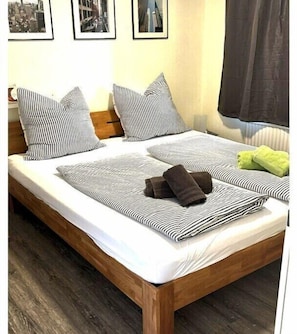 Ein Bett mit gestreifter Bettwäsche, Kissen und zwei Handtüchern.