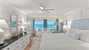Une chambre d’hôtel équipée d’un lit, d’un bureau, d’une chaise, d’une commode et offrant une vue sur l’océan.