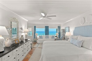 Ein Hotelzimmer mit Bett, Schreibtisch, Stuhl, Kommode und Meerblick.
