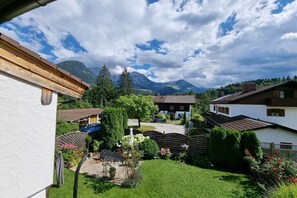 Ein Wohngebiet mit Häusern, einem Garten und Bergen im Hintergrund.