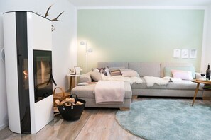 Ein modernes Wohnzimmer mit einer Couch, einem Kamin, einer Lampe und einem Teppich.