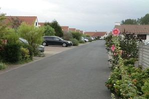 A residential street with parked cars and houses with red-tiled roofs. - Holiday home in De Haan with swimming pool (De Haan)