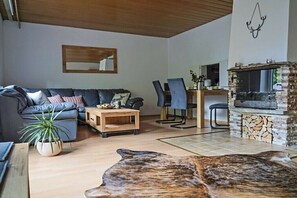 Ein modernes Wohnzimmer mit einer Couch, einem Couchtisch und einem Kamin aus Stein.