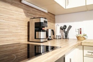Eine moderne Küche mit integrierter Kaffeemaschine, Wasserkocher und Messerblock auf der Arbeitsfläche.