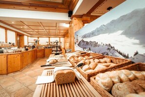 Ein Buffetbereich mit Holzsäcken und einer Wandmalerei mit Bergblick.