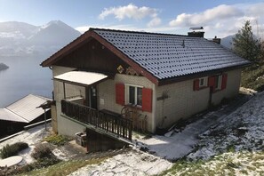 A chalet with a sloped roof, a balcony, and a view of mountains. - Holiday home in Vitznau with swimming pool (Vitznau)