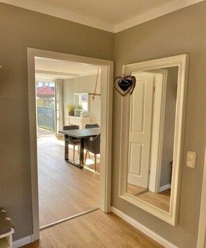 Ein Zimmer mit einer Tür, einer herzförmigen Dekoration und Blick auf einen Essbereich mit Tisch und Stühlen.