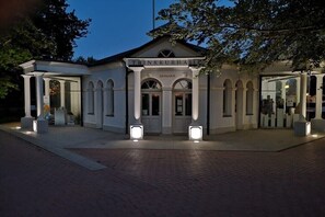 A building with a classical architectural style, featuring a central entrance with arched doorways and a sign above. - Large Baltic Sea nest (Boltenhagen)