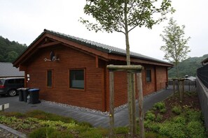 Eine Holzhütte mit geneigtem Dach, einer Satellitenschüssel und einem kleinen Fenster.