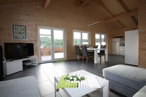 A modern interior with a TV, dining area, and kitchen. - Holiday home in Rieden with swimming pool (Rieden)