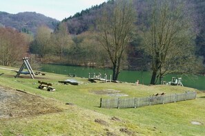 A park with a swing set, benches, and a fenced area. - Holiday home in Rieden with swimming pool (Rieden)