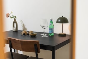 Et spisebord med en vase, to vinglas, en vandflaske og en lampe.