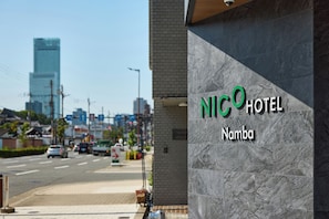 A hotel sign with 'NICOHOTEL Namba' written on a grey stone facade. - NICO HOTEL Osaka Namba (Osaka)