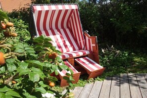 Ein roter und weiß gestreifter Lounge-Sessel im Garten.