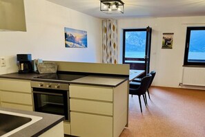 Eine kompakte Küche mit Herd, Backofen und einem Essbereich mit Stühlen und Tisch.