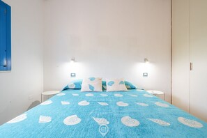 Ein Schlafzimmer mit einem Bett, zwei Nachttischen und einem Kleiderschrank.