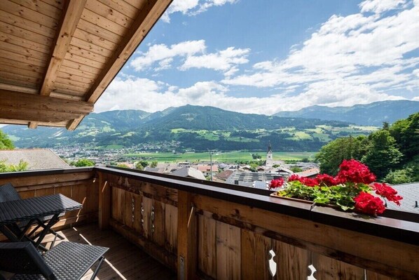 Ein Holzbalkon mit Blick auf eine Stadt und Berge.