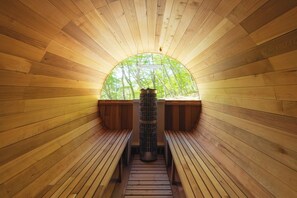 Interior de madera con un tragaluz circular, bancos y una columna central.