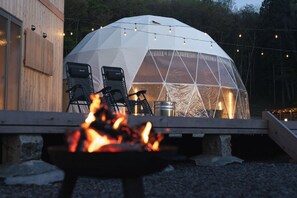 Una estructura de domo geodésico con un hogar a la vista.