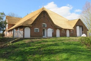 Ein Backsteinhaus mit einem dreieckigen Dach und weißen Türen.