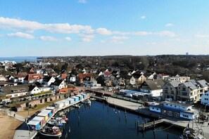 Eine Küstenstadt mit einem Yachthafen, Häusern und einem Gebäude in der Ferne.