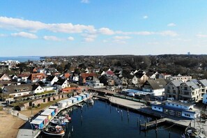 Eine Küstenstadt mit einem Hafen, Häusern und einem Gebäude in der Ferne.