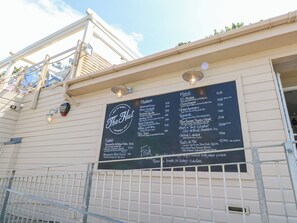 A menu board for 'The Hut' restaurant with various dishes listed and prices. - 8 Manor Villas (Totland Bay)