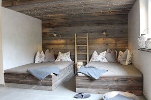 A cozy room with two beds, a ladder, and decorative wall lights. - Holiday apartment with 1 bedroom (Grainau)