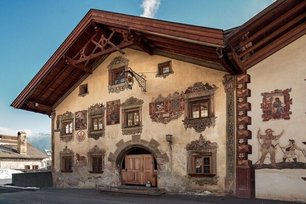 A traditional building with a wooden facade, multiple windows, and a prominent entrance. - Apartment with mountain view (Ladis)