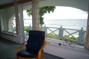 Ein Zimmer mit Meerblick, ein Sessel, eine Heizung und ein Fahrrad.