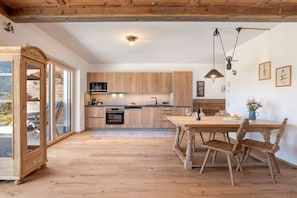 Eine moderne Küche mit Holzschränken, einem Esstisch und Stühlen.