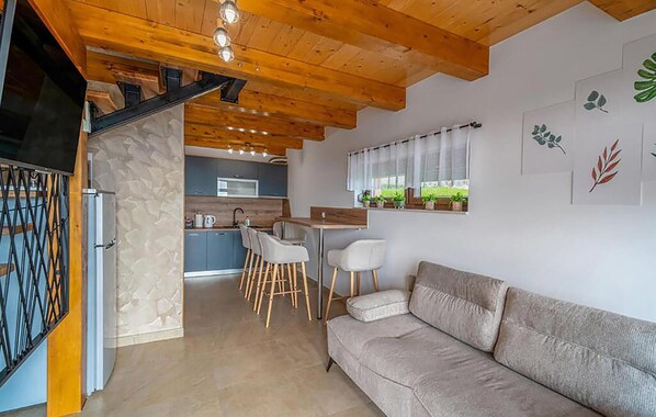 Ein modernes Interieur mit Sofa, Essbereich, Küche und Treppe.