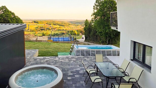A hot tub, outdoor seating, and a view of a swimming pool and landscape. - 3 bedroom cozy home in Kalnik (Kalnik)