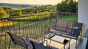 A balcony with two chairs and a table, overlooking a scenic landscape. - 3 bedroom cozy home in Kalnik (Kalnik)