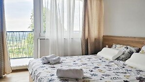 A bedroom with a bed, a window with curtains, and a view of greenery outside. - 3 bedroom cozy home in Kalnik (Kalnik)