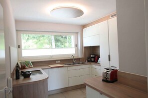 Eine moderne Küche mit Fenster, Spüle, Toaster und Kaffeemaschine.