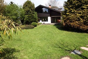 Ein modernes Haus mit gepflegtem Rasen, Schornstein und großem Gartenfenster.