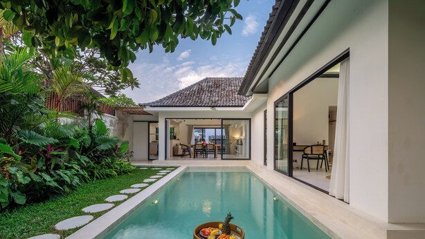 Ein modernes Haus mit Swimmingpool, Essbereich und üppigem Grün.