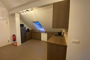 Una cocina moderna con tragaluz, lavavajillas y microondas.