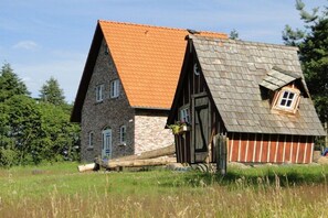 A rustic building with a stone facade and a wooden structure with a sloped roof. - Hawthorn in the heathland magic (Bispingen)