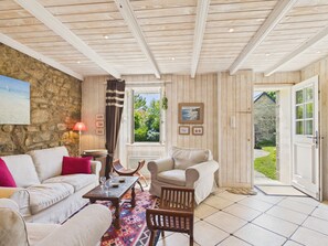 A cozy room with a stone wall, wooden ceiling, and a view of greenery outside. - Authentic house for 11, close to the beach (Landéda)
