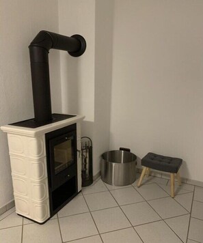 A modern kitchen with a built-in stove, a stainless steel pot, and a stool. - Holiday apartment with 1 bedroom (Altenkirchen Lahn-Dill-Kreis)