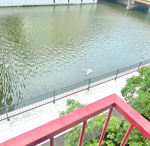 A river with a bridge, a railing, and greenery. - Osaka Dotonbori Riverside Walking distance 5 min / Osaka City Ōsaka (Osaka City)