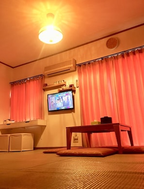 A room with a television mounted on the wall, a small table, and a futon bed. - Osaka Dotonbori Riverside Walking distance 5 min / Osaka City Ōsaka (Osaka City)