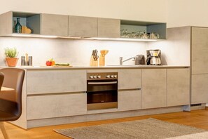 Eine moderne Küche mit eingebauten Geräten, einer Arbeitsplatte und einem Holzboden.