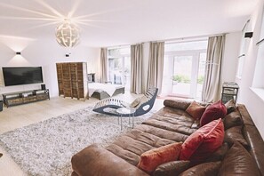 Ein Wohnzimmer mit einer großen Couch, einem Couchtisch und einem Fernseher.