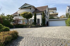 Ein Wohnhaus mit einer geschwungenen Auffahrt, einer Garage und einem gepflegten Garten.